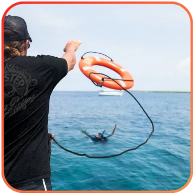 A person throwing a lifebuoy to a diver in the water.